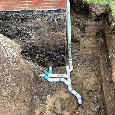 Exposed sewer line and cleanout in a dug trench
