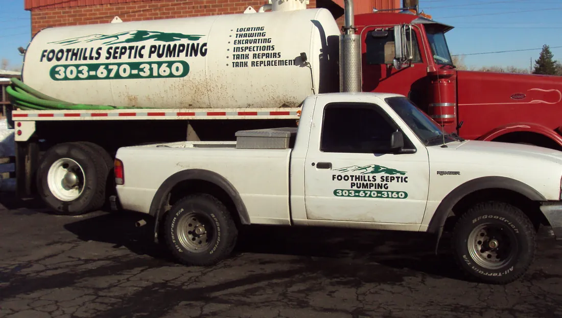 The red pump truck and white pickup, both lettered Foothills Septic Pumping